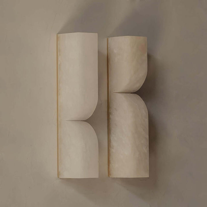Pair of unlit Cavira alabaster wall sconces mounted side by side to show their sculptural profiles
