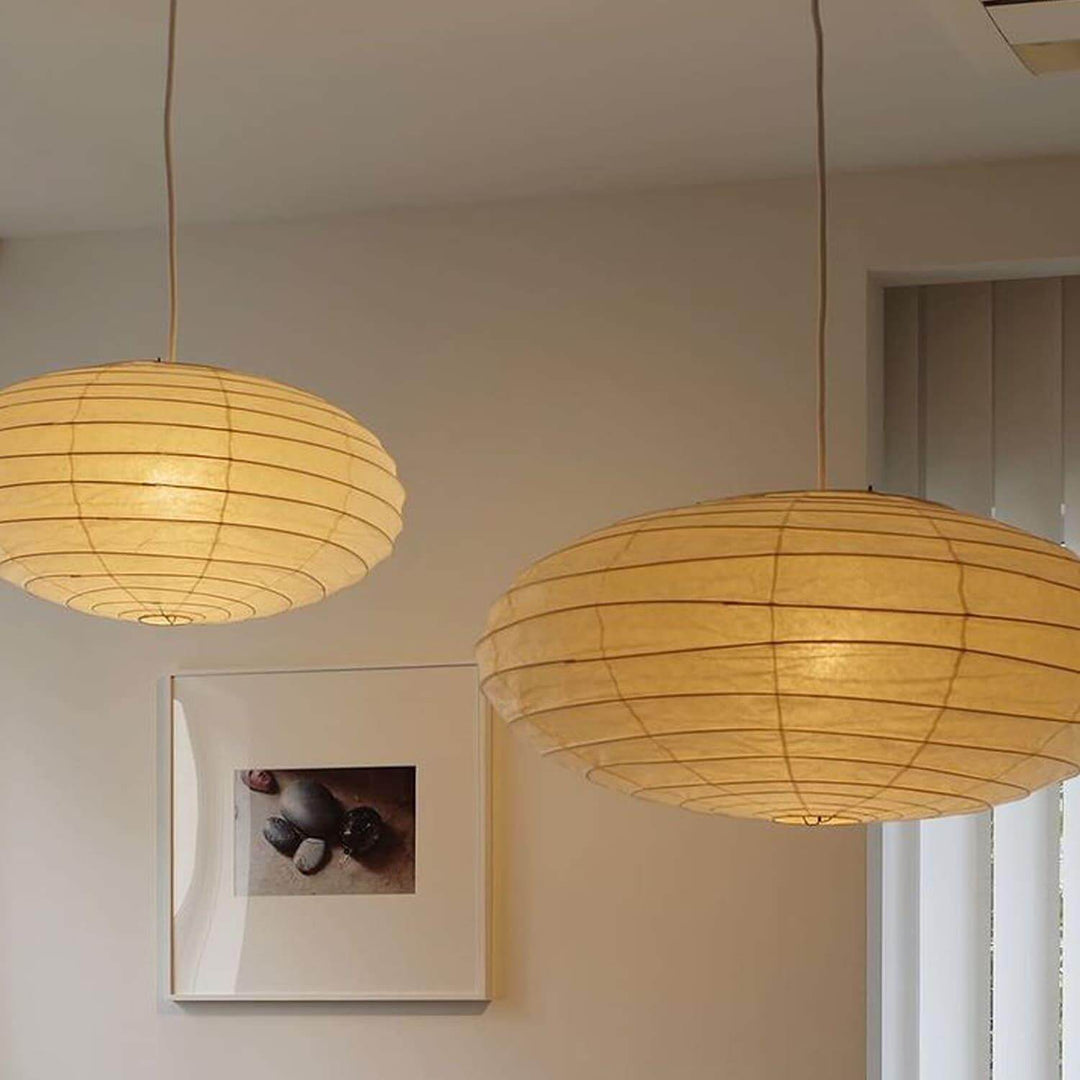 Two washi paper pendant lights hanging in a warm interior.