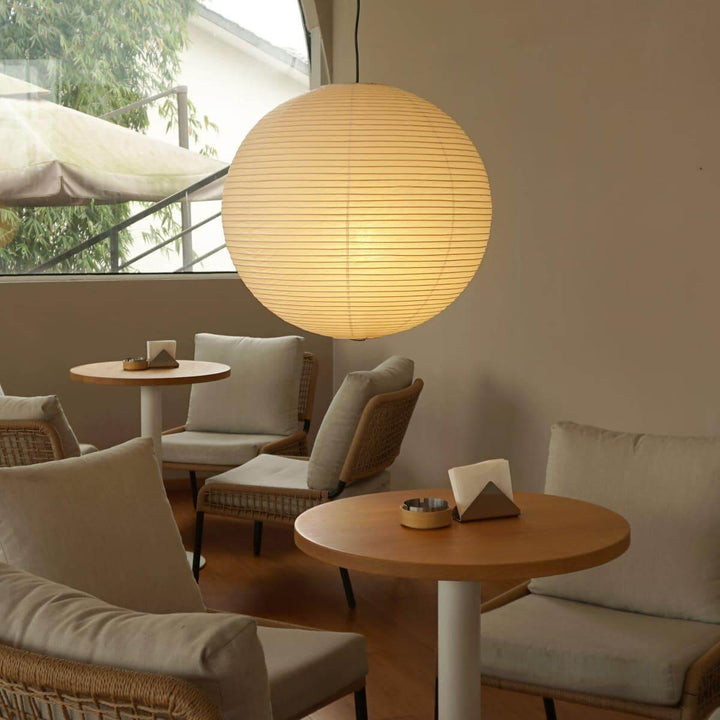 Large paper globe pendant light in a warm café lounge setting