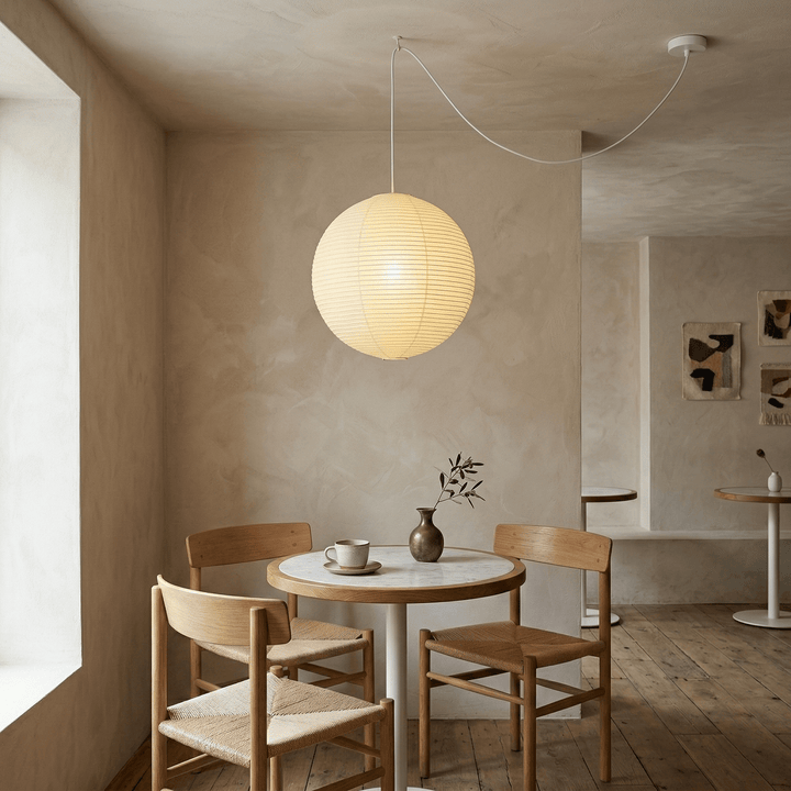Plug-in paper globe pendant light above a small café style table