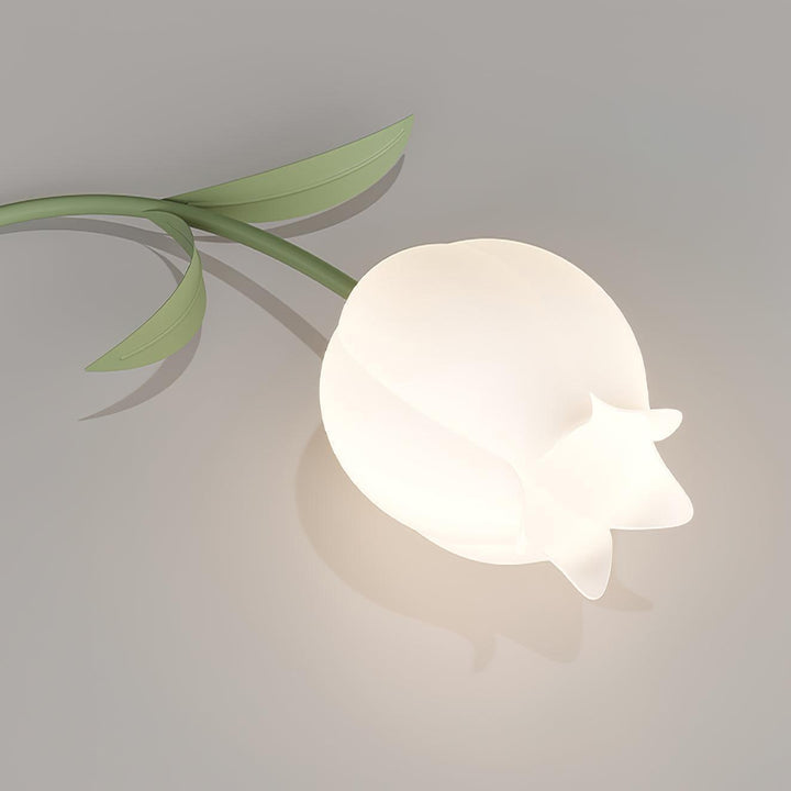 Close-up of a softly glowing cream lily-shaped shade on the Ricko green ceiling light.
