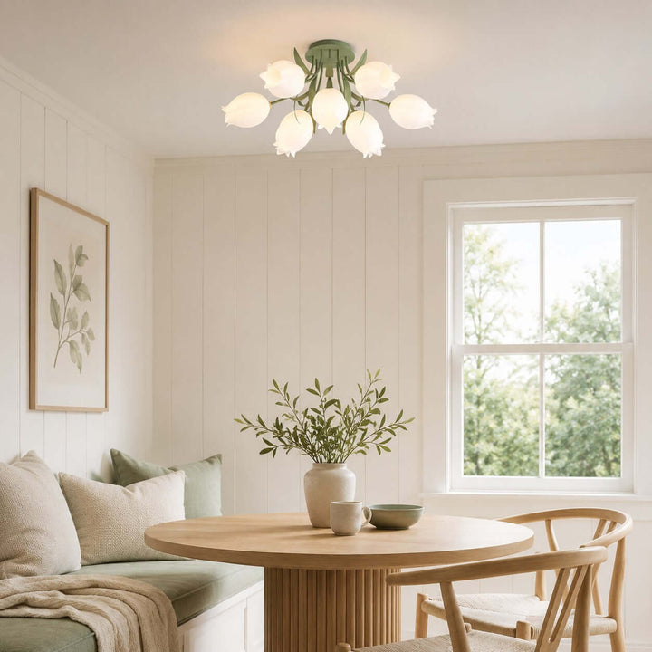 Ricko green floral ceiling light illuminating a breakfast nook with a round wood table and built-in bench.