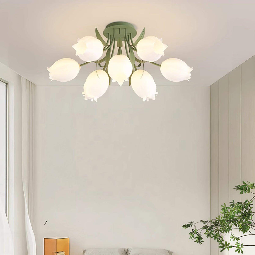 Close view of the Ricko green ceiling light with curved leaf arms and softly glowing cream flower shades.