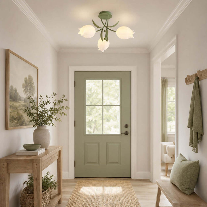 Three-light Ricko ceiling fixture with green leaf arms and cream flower shades in a bright entryway.