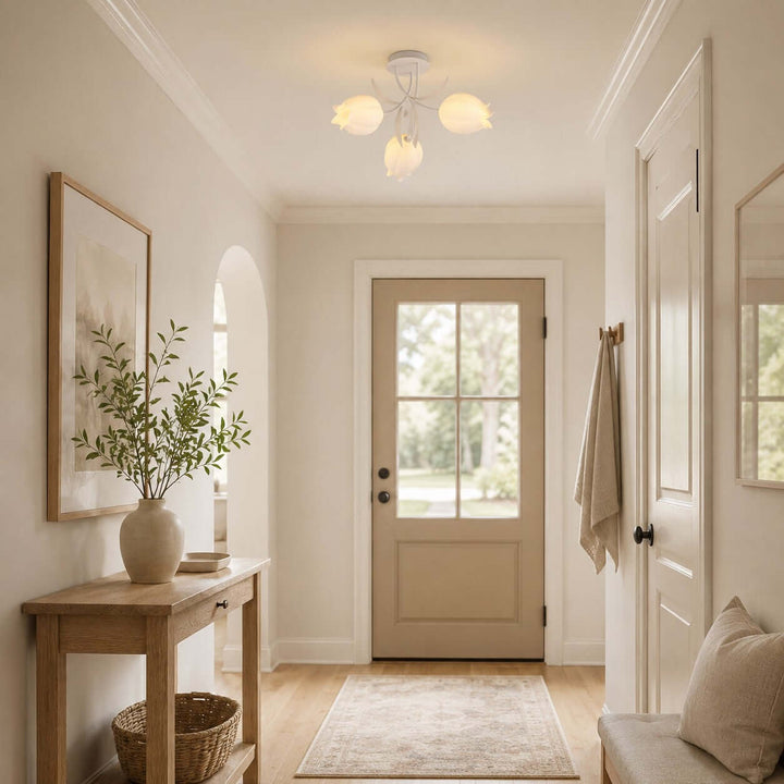 Three-light Ricko white ceiling fixture illuminating a neutral entryway with botanical decor.