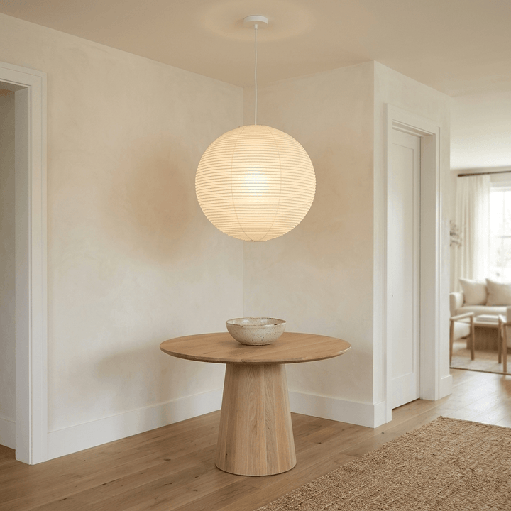 Washi paper globe pendant light above a round pedestal table