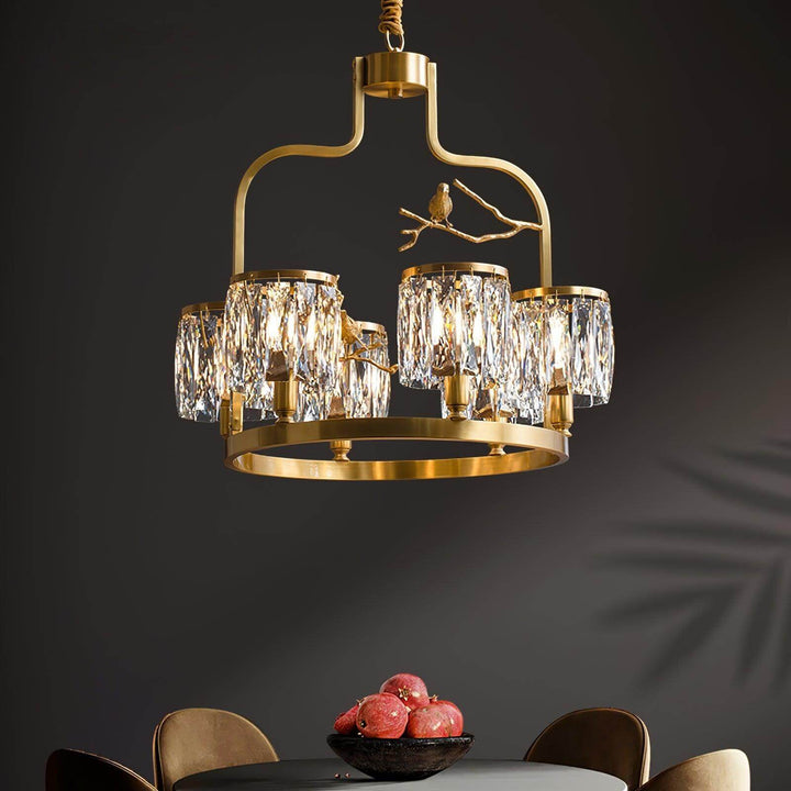 Six-light Crystal Bird Chandelier in brass and clear crystal shown illuminated against a dark background