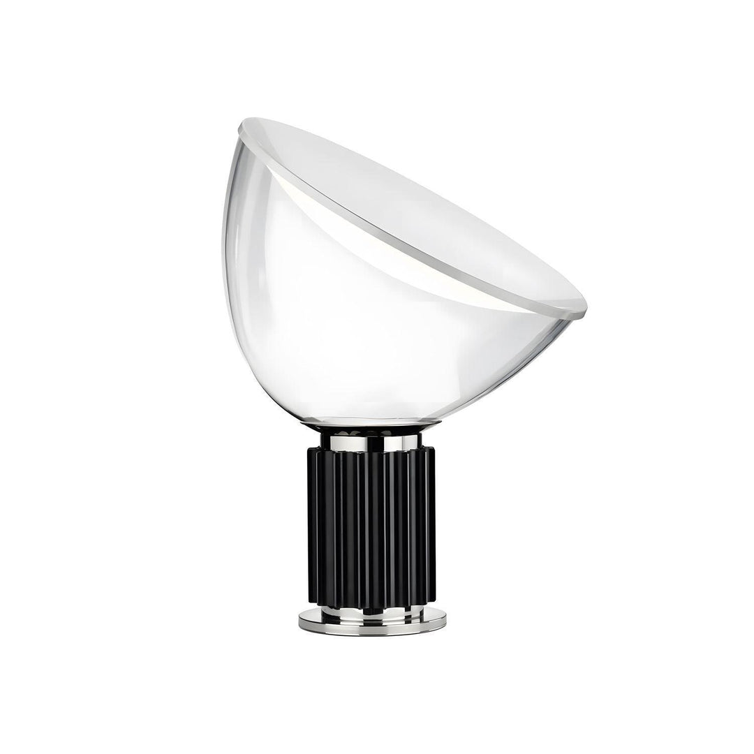 Taccia glass table lamp with an angled white diffuser and black fluted aluminum base on a white background