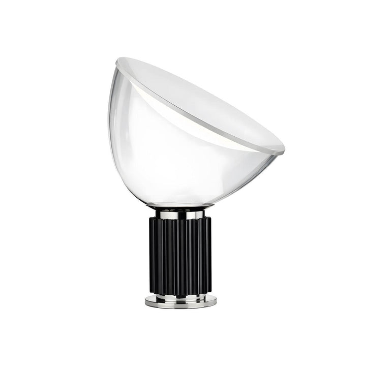 Taccia glass table lamp with an angled white diffuser and black fluted aluminum base on a white background