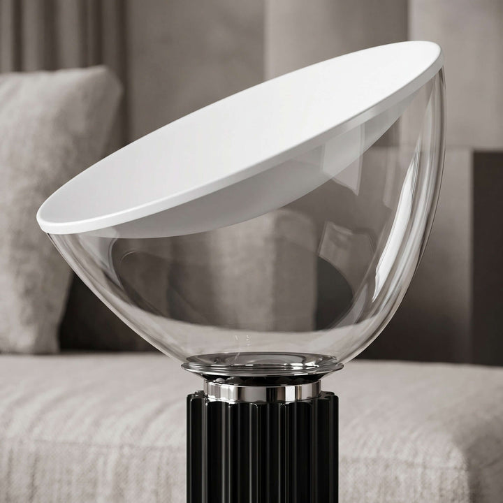 Close-up of the Taccia table lamp clear glass bowl, angled white diffuser and black fluted base