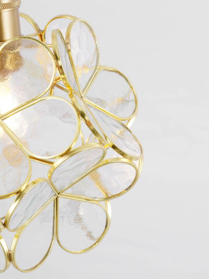 Close-up of textured transparent glass petals edged with an antique brass frame