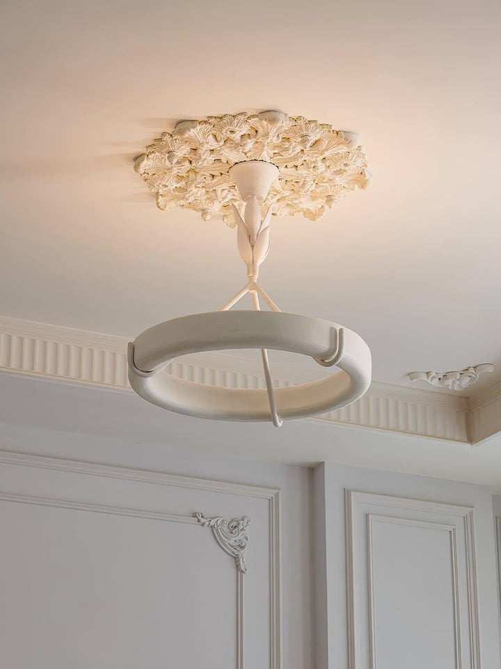 White Tinsley chandelier installed beneath a floral plaster ceiling medallion with soft warm uplight.