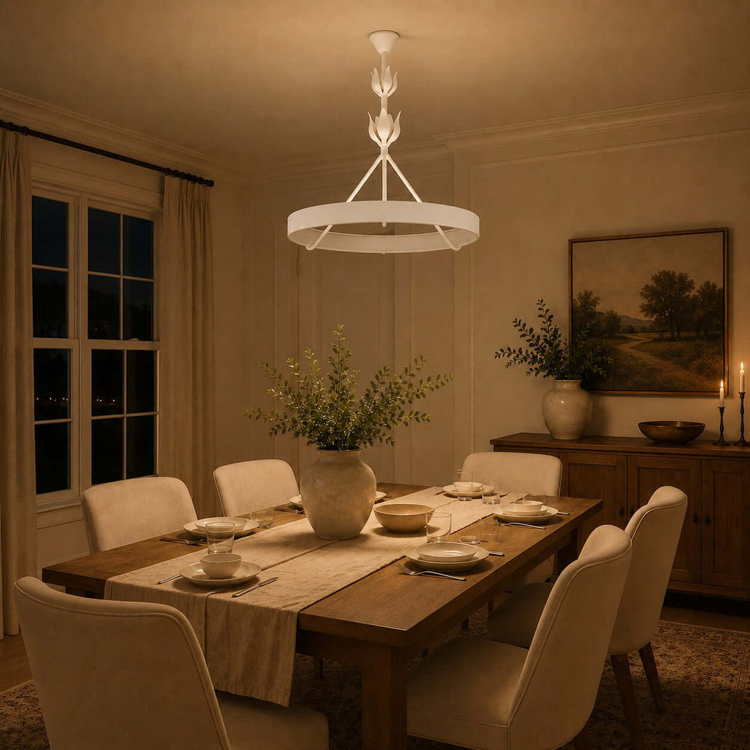 White Tinsley dining room chandelier illuminating a set wood table in a warm evening interior.