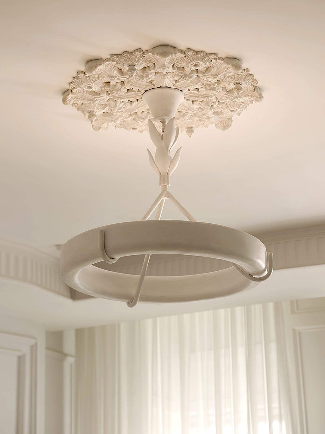 Close-up of the Tinsley chandelier’s sculpted leaf stem, plaster ring, supports, and floral ceiling medallion.