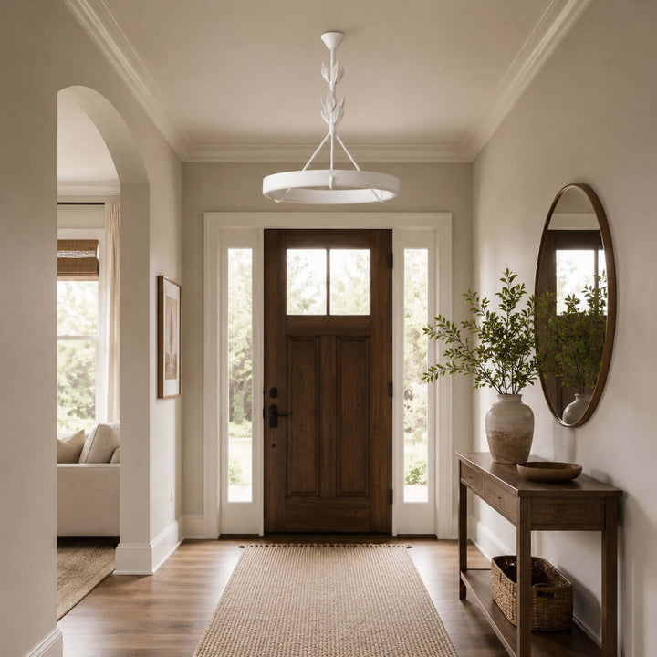 Tinsley plaster chandelier above a bright foyer with a wood front door and oval wall mirror.