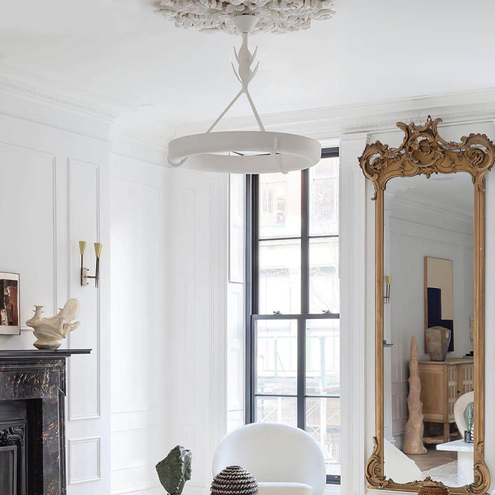 Sculptural white Tinsley chandelier suspended from a decorative ceiling medallion in a classic living room.