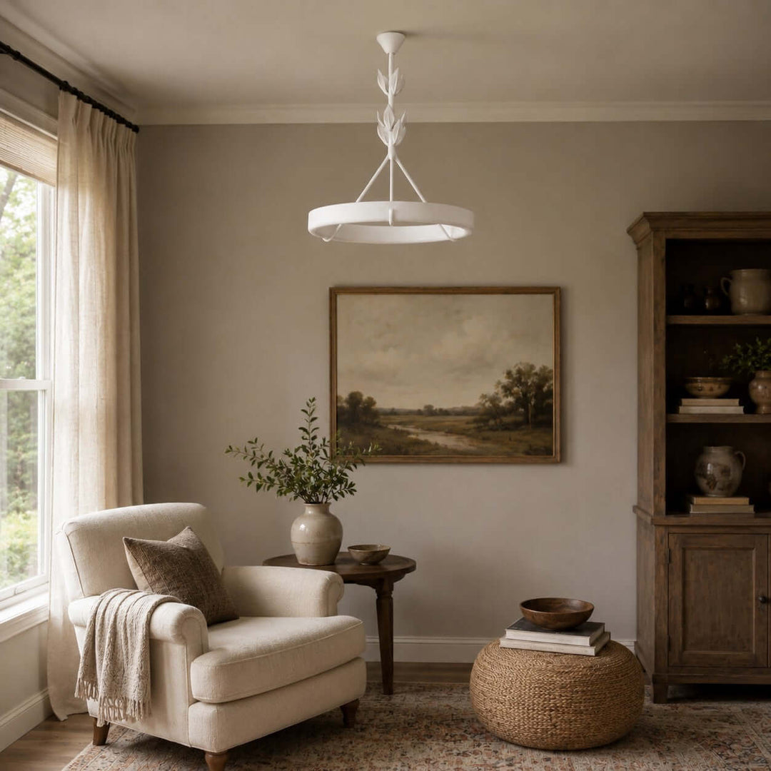 White Tinsley chandelier above a quiet reading room with an upholstered chair and wood cabinet.