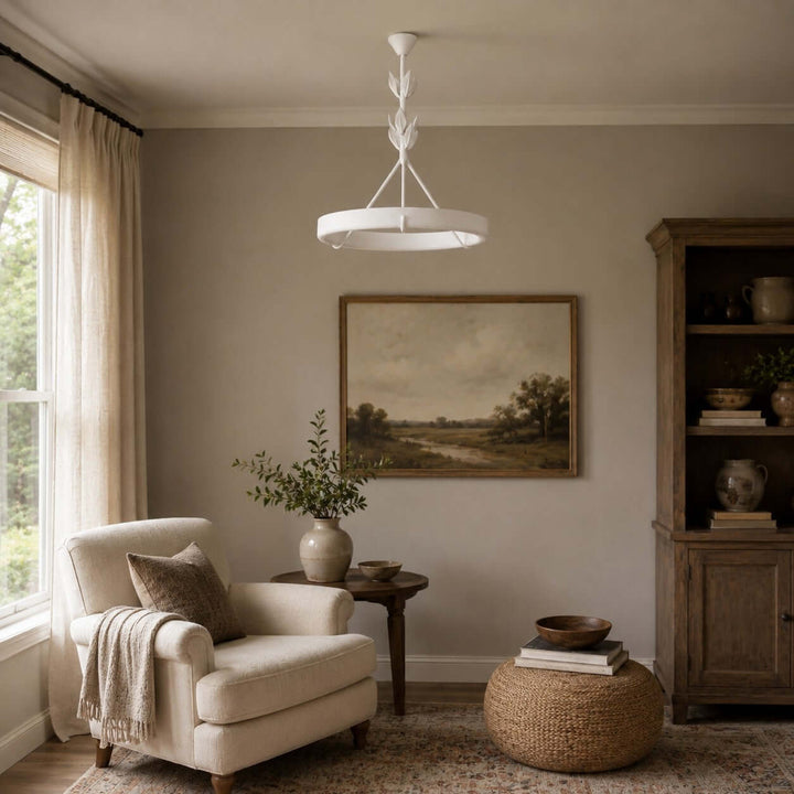 White Tinsley chandelier above a quiet reading room with an upholstered chair and wood cabinet.