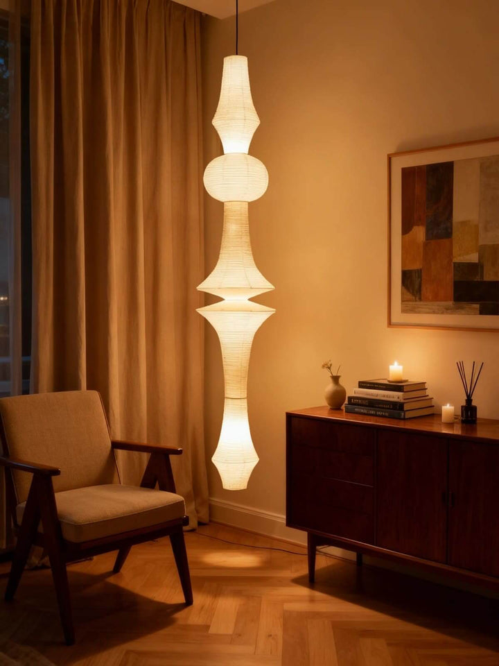 Two Washi paper pendant lights suspended in a bright double-height living room with a fireplace