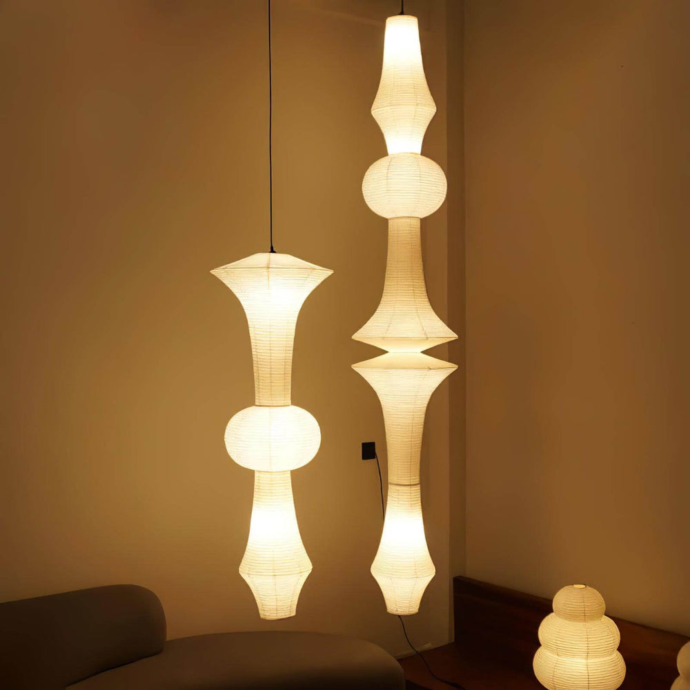Two sculptural Washi paper corner pendant lights glowing warmly in a neutral interior