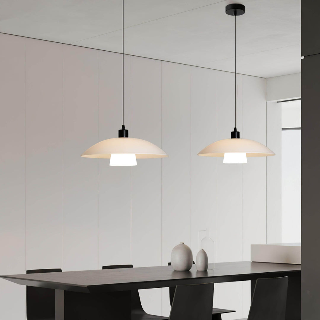 Pair of Verona pendant lights above a dark table in a minimalist black and white dining room