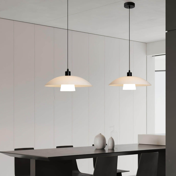 Pair of Verona pendant lights above a dark table in a minimalist black and white dining room