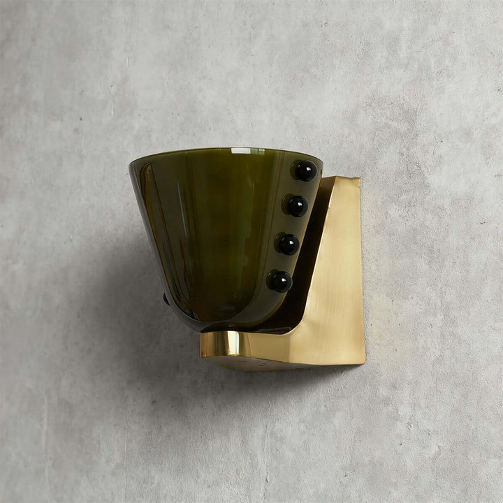Side view of a green Vestra wall sconce with black accents and a gold base
