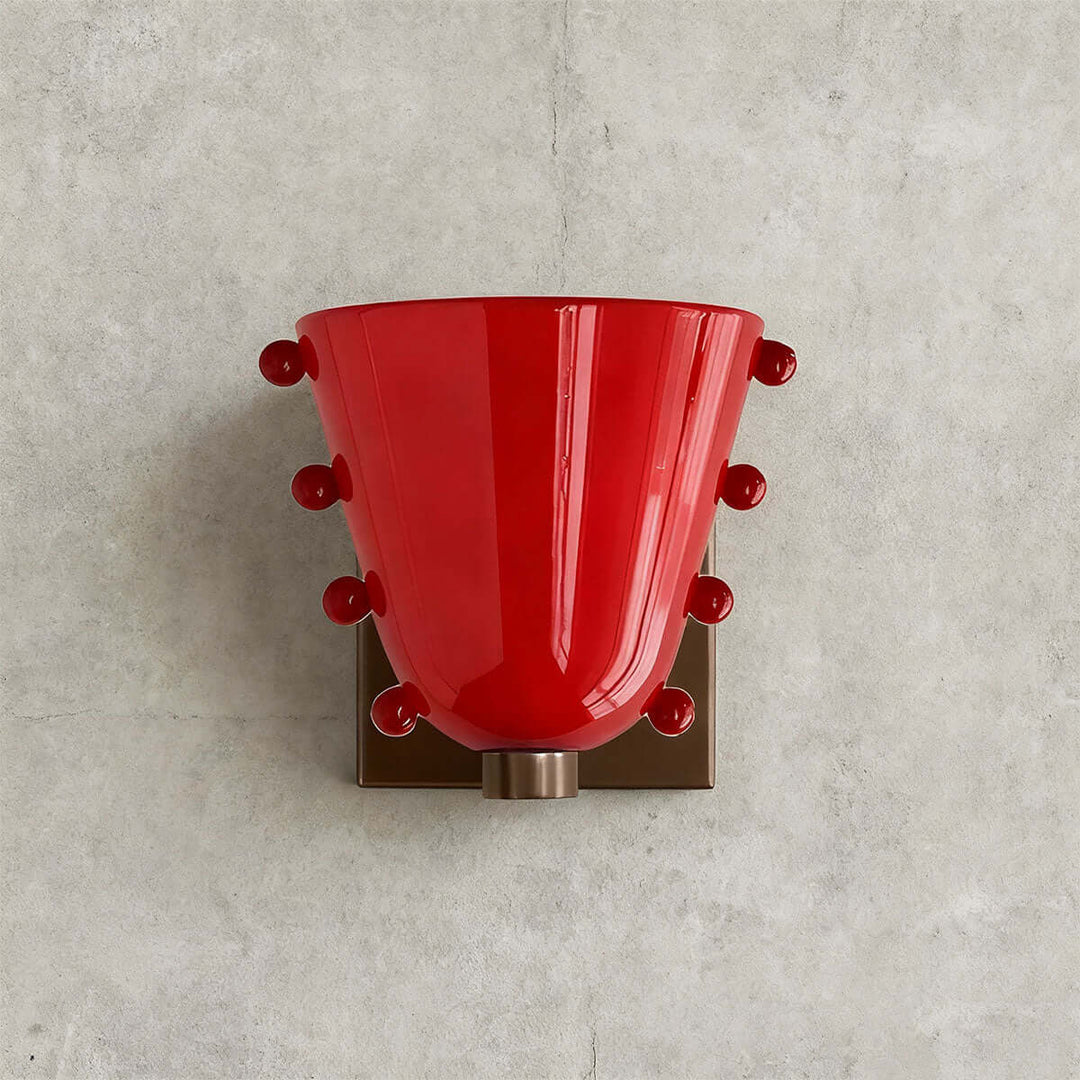 Front view of a red Vestra wall sconce with matching red sphere accents