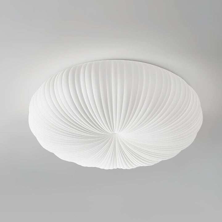 White round flush mount ceiling light with a pleated shade shown on a gray background.