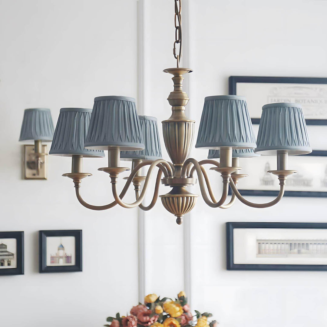 Eryn chandelier with blue pleated shades hanging above a dining table.