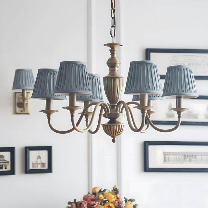 Eryn chandelier with blue pleated shades hanging above a dining table.