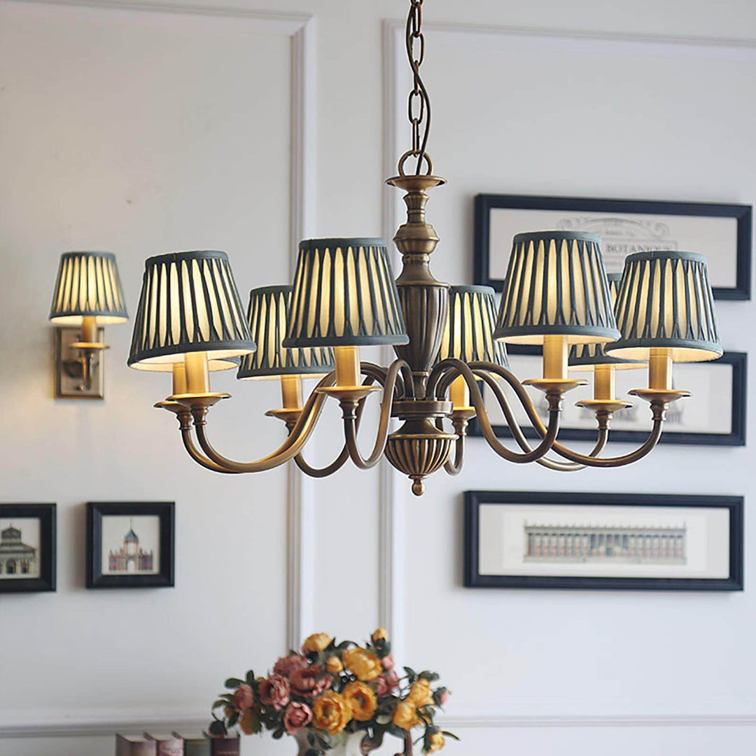 Brass chandelier with pleated shades displayed in a bright dining room.
