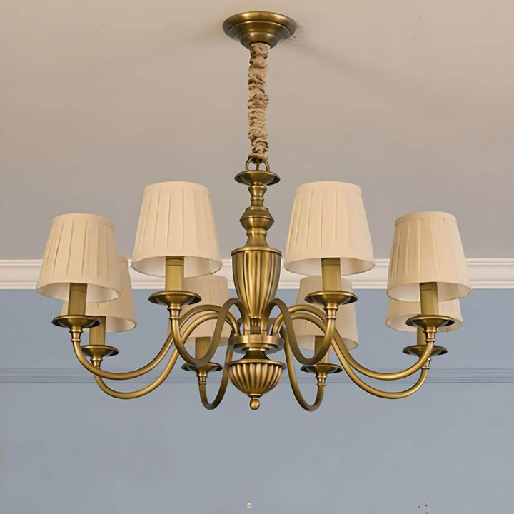 Eight-light Eryn chandelier with beige pleated shades and a brass frame.