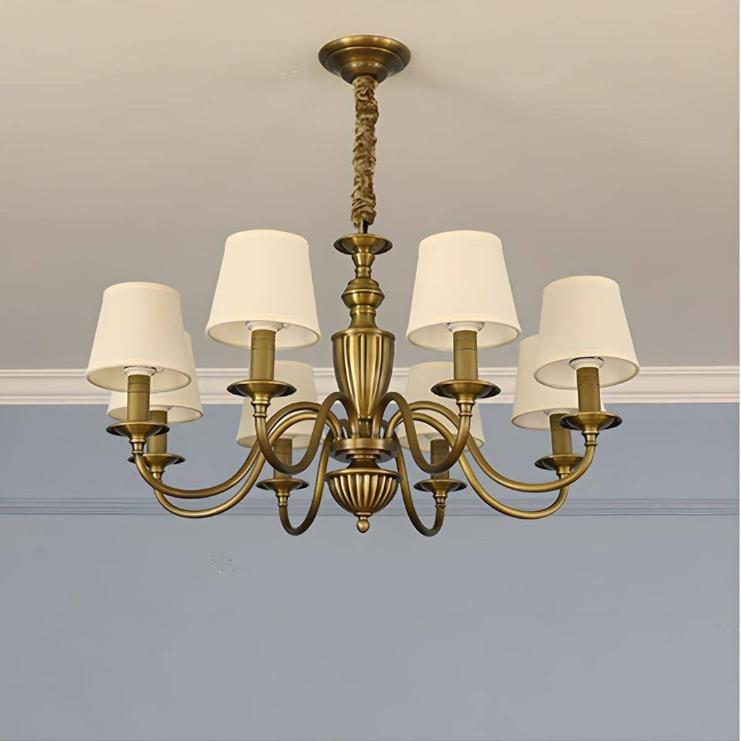 Eight-light Eryn chandelier with warm white shades and brass arms.
