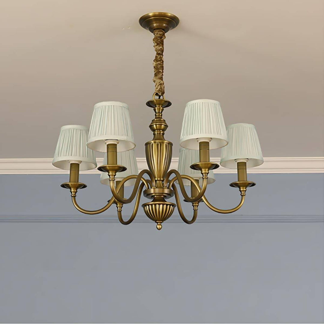 Six-light Eryn chandelier with white shades and a brass frame.
