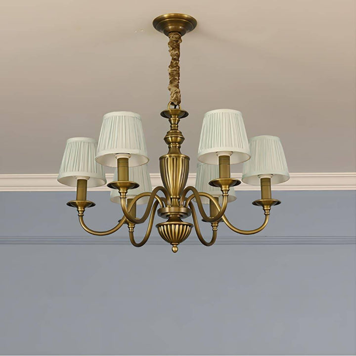 Six-light Eryn chandelier with white shades and a brass frame.