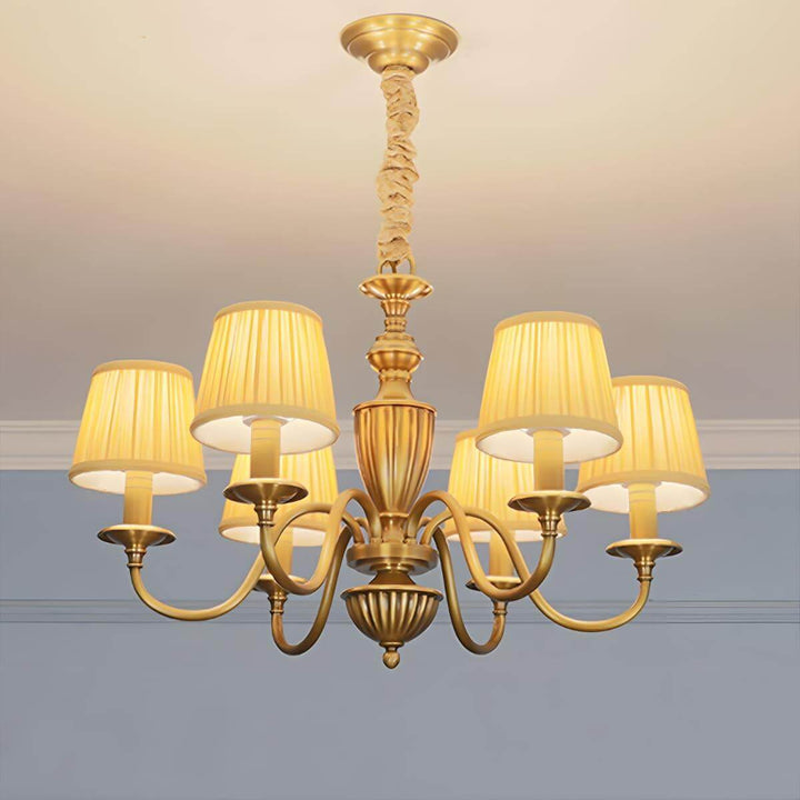 Six-light Eryn chandelier with yellow shades glowing warmly.