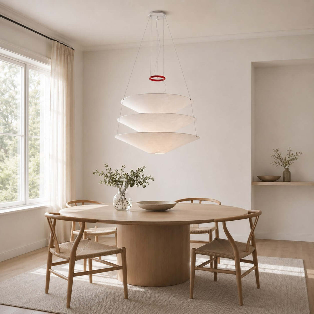 Floating pendant light centered over a round dining table in a bright room.
