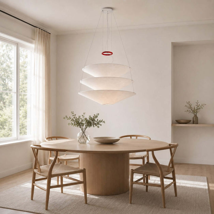 Floating pendant light centered over a round dining table in a bright room.
