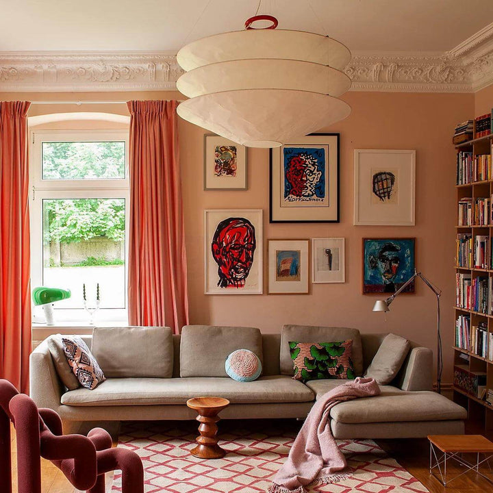 Floating pendant light hanging in a colorful living room with framed wall art.