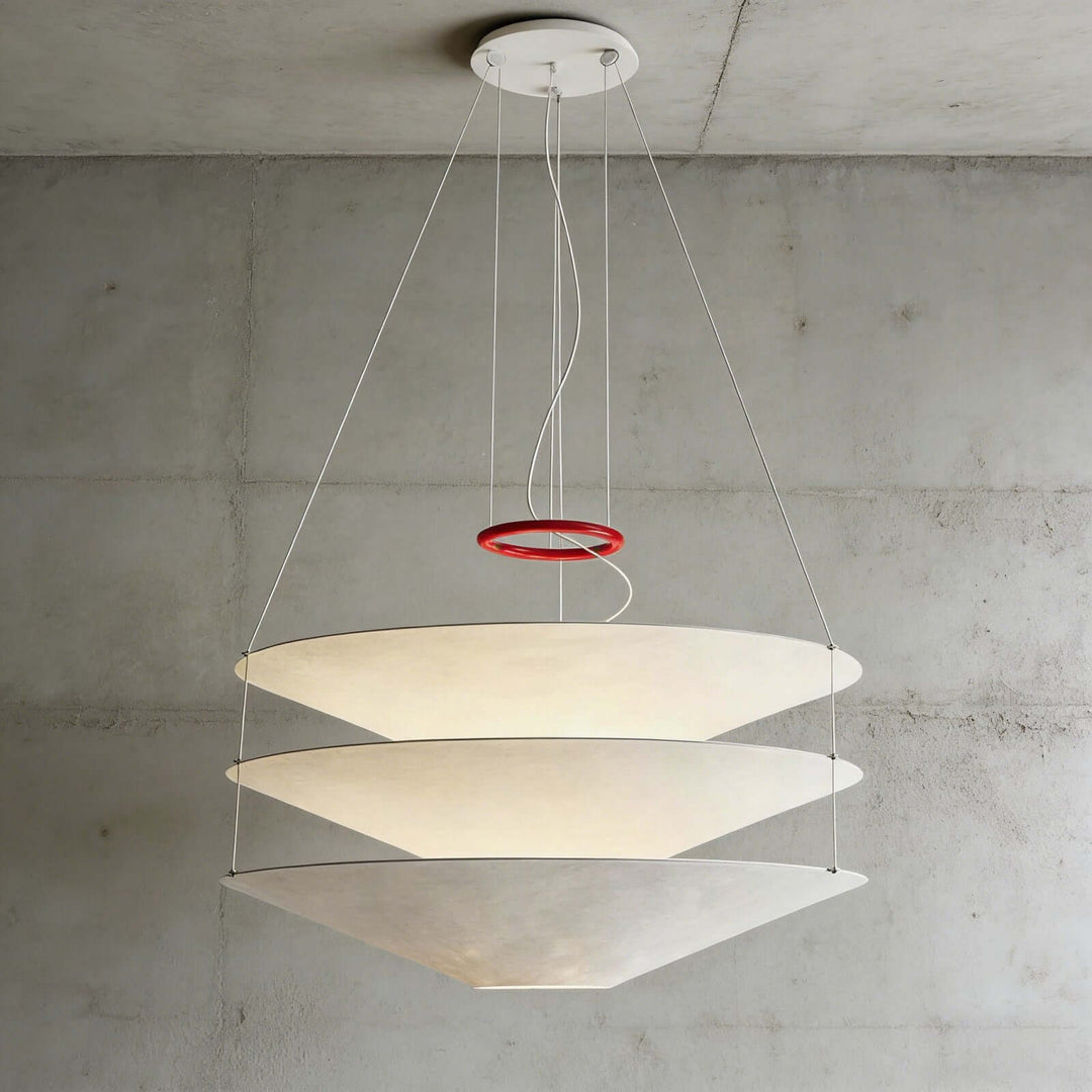 Large floating pendant light with layered white shades on a concrete wall background.