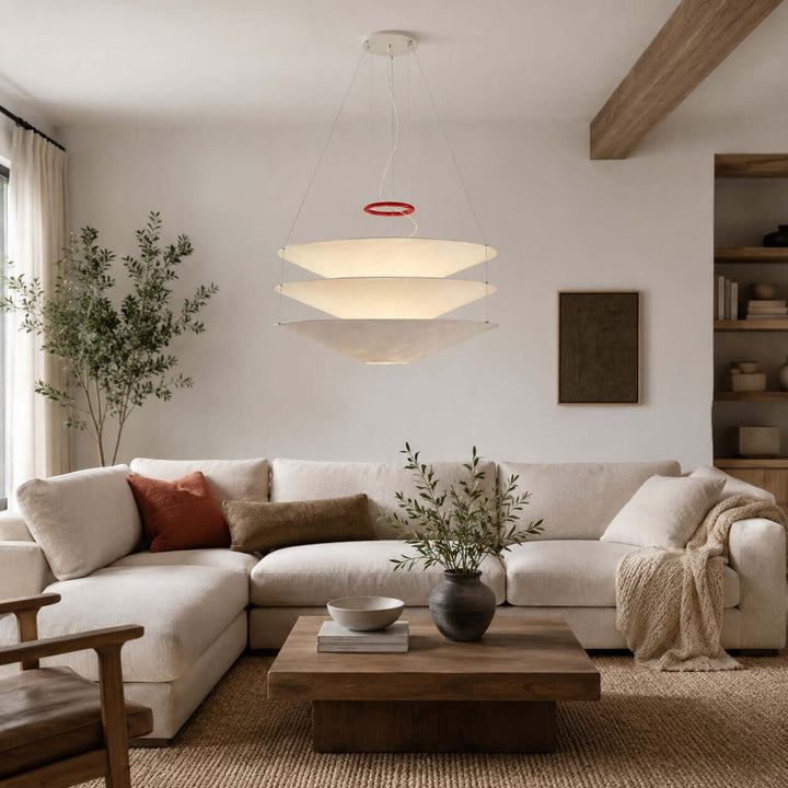 Layered white pendant light hanging above a living room sofa and coffee table.