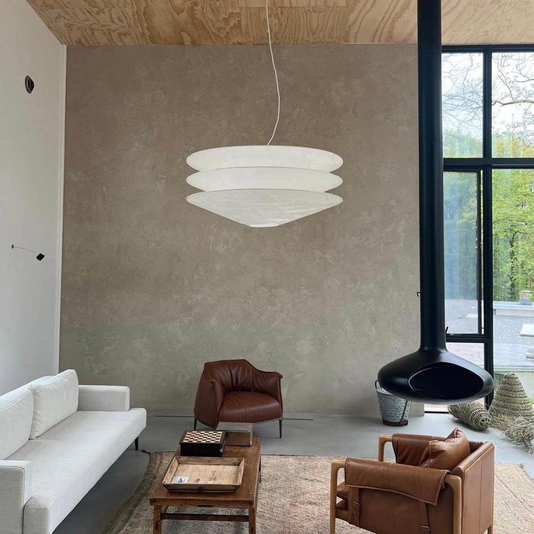 White floating pendant light in a modern living room with a sofa and chair.