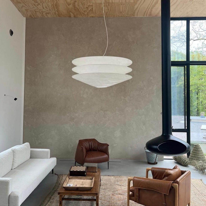 White floating pendant light in a modern living room with a sofa and chair.