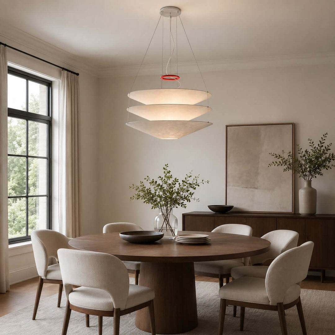Floating pendant light above a round dining table in a bright dining room.