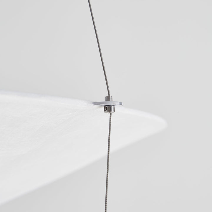 Close-up of a suspension wire attached to the edge of the layered shade.