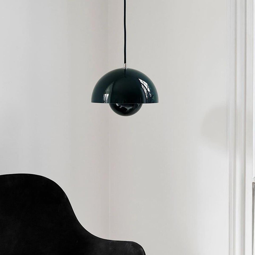 Dark green Flowerpot pendant lamp shown near an armchair.