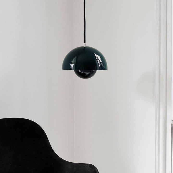 Dark green Flowerpot pendant lamp shown near an armchair.