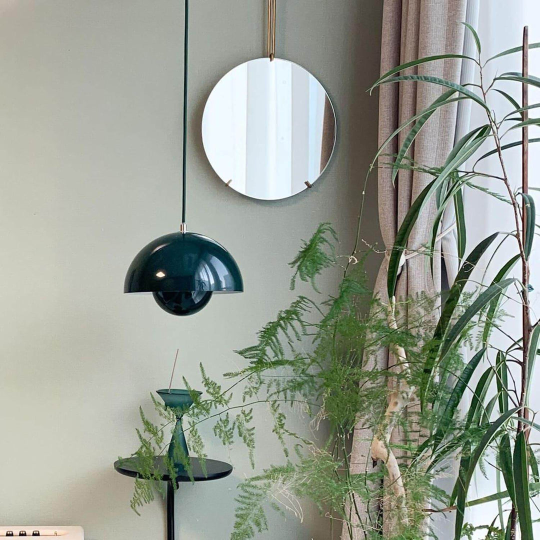 Dark green Flowerpot pendant lamp shown near a mirror and plants.