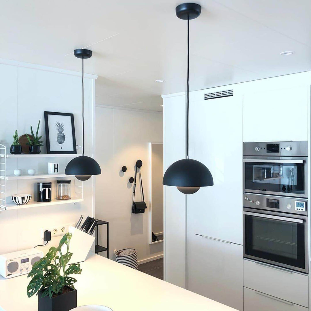 Matte black Flowerpot pendant lamps shown over a kitchen counter.